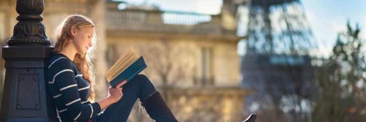 Beautiful young woman in Paris, reading a book