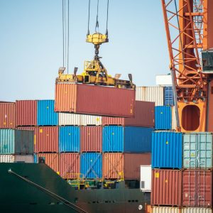 puerto martítimo, transportando contenedores con un grúa