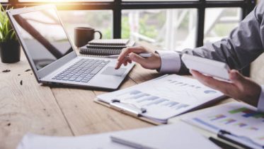 Portrait of a businessman working on a tablet computer in a modern office. Make an account analysis report. real estate investment information financial and tax system concepts