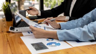 Meeting room atmosphere, business people meeting together on finance topics, they are working together to plan and solve corporate finance issues. Concept of business administration and finance.