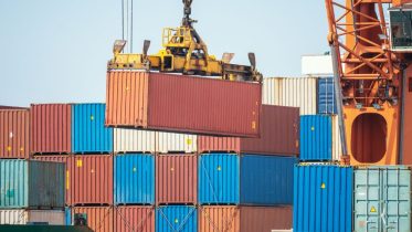 puerto martítimo, transportando contenedores con un grúa
