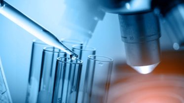 microscope with lab glassware, science laboratory research and development concept