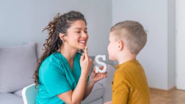 Speech therapist and little patient training articulation. Speech therapist teaches the boys to say the letter S. Shot of a speech therapist during a session with a little boy